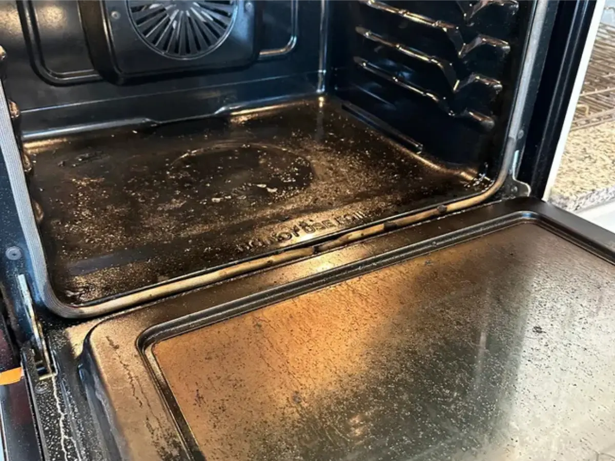 alt="The interior of a very greasy oven with baked-on grime before a professional deep cleaning service in Maryland."