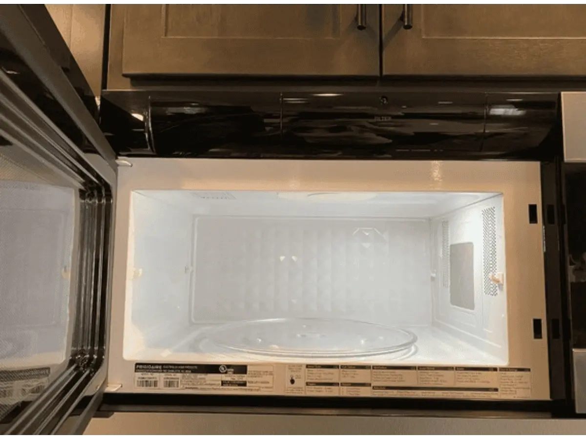 alt="After photo of the same microwave, now spotless, sanitized, and looking brand new after a professional kitchen cleaning."