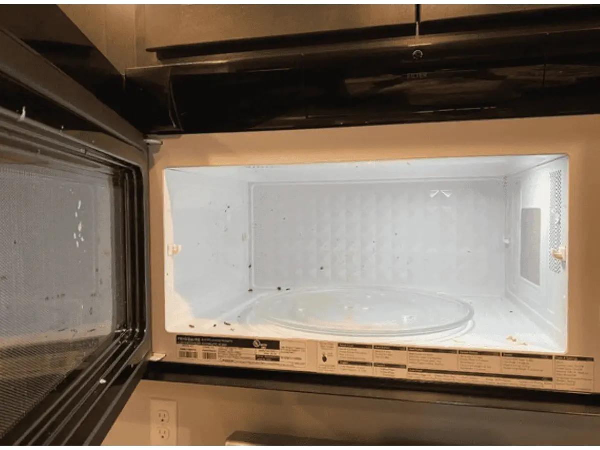 alt="Before photo of a microwave interior with heavy, baked-on food splatter and grime in a Maryland home."