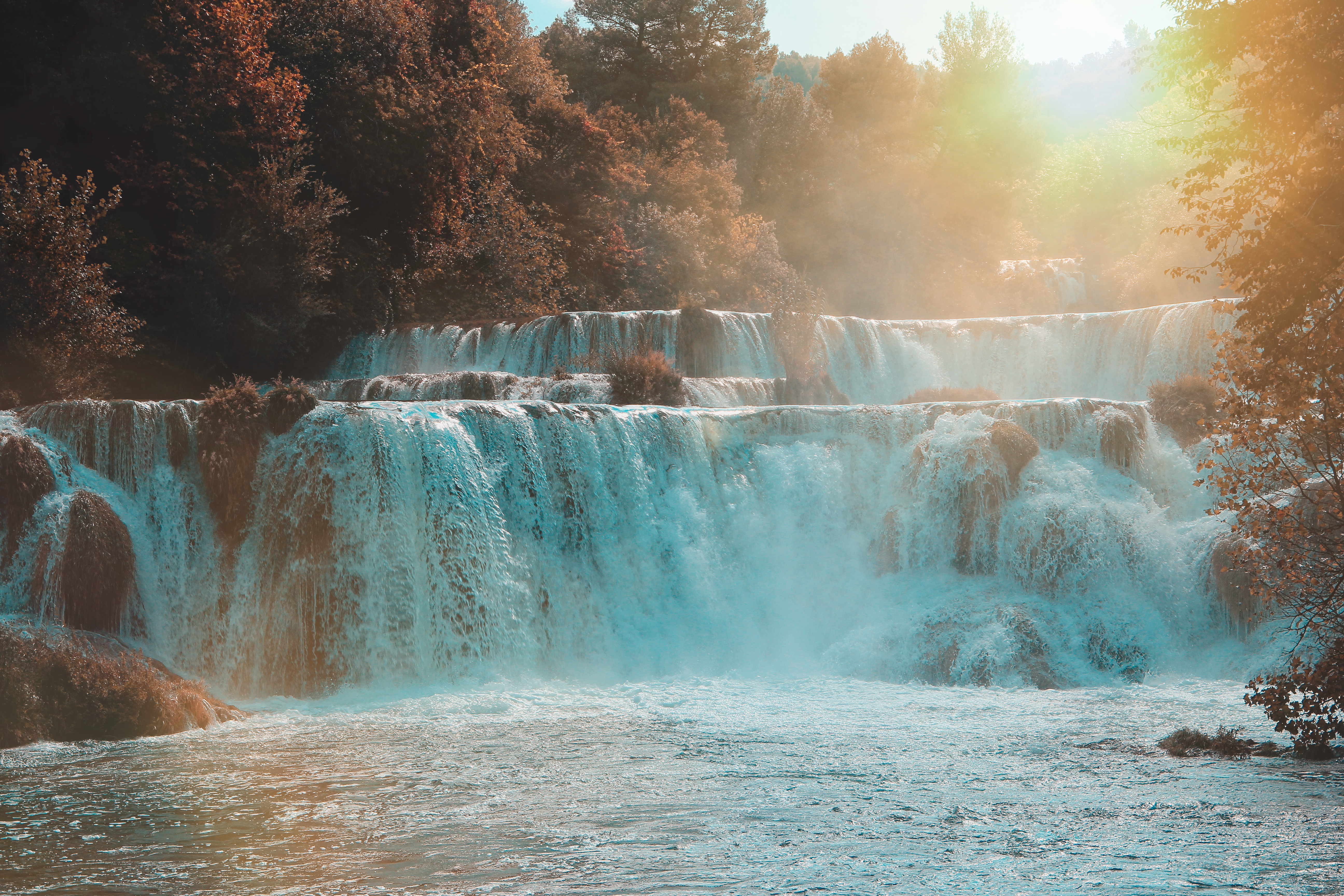 Multiple streams flowing into multiple waterfalls symbolizing The Waterfall Wealth Method.