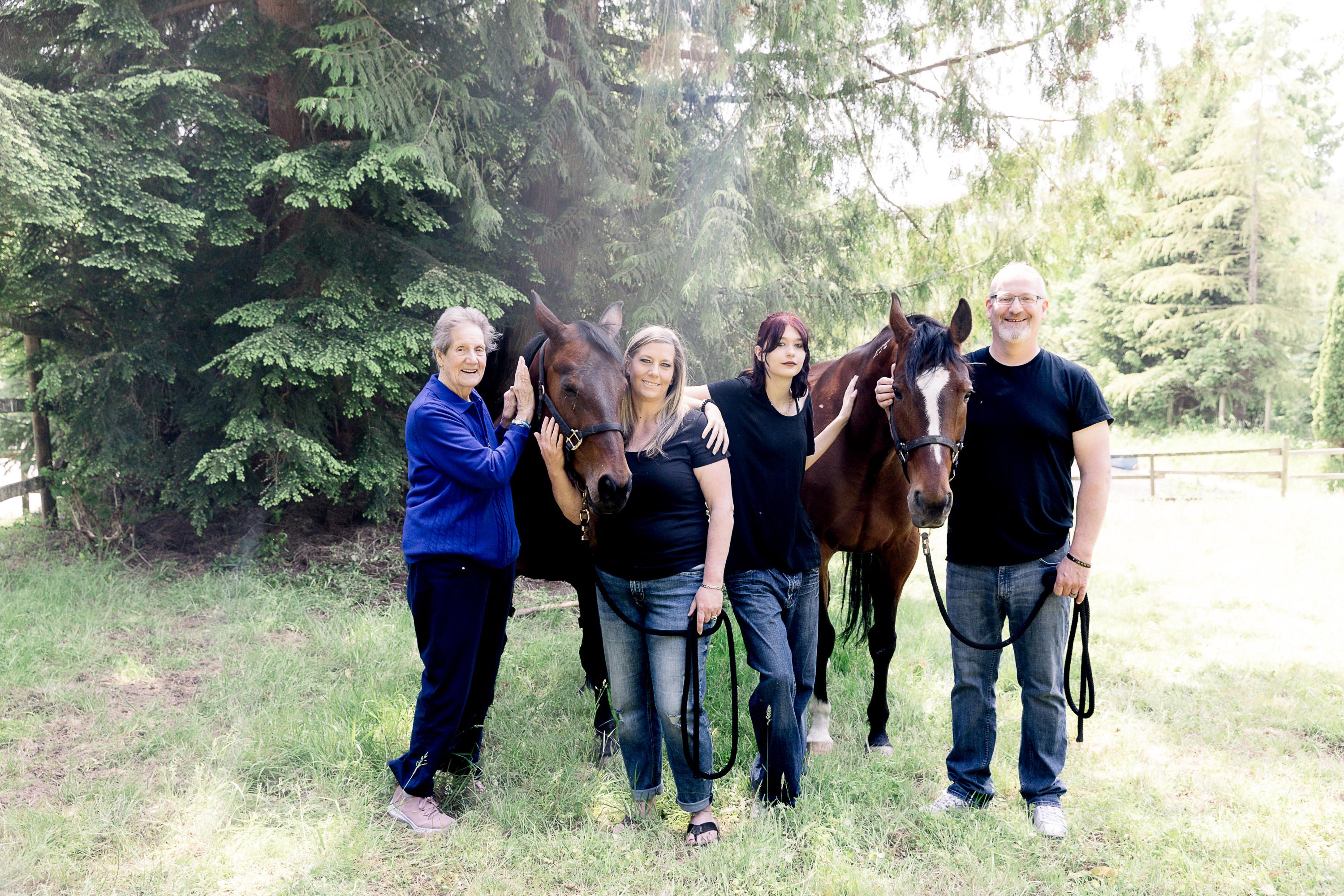 family taking a photo with horses