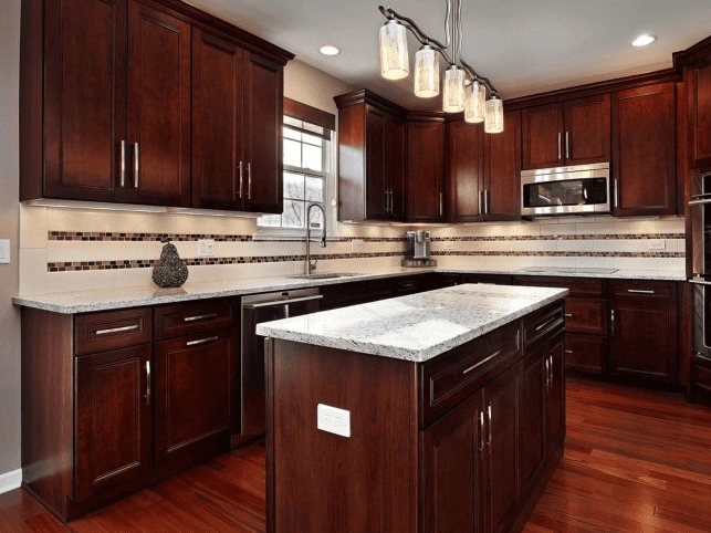 a kitchen remodeling features rich wood cabinets and a stylish granite island.