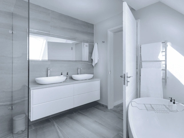 a bathroom remodeling features a sleek double vanity and modern freestanding tub design.