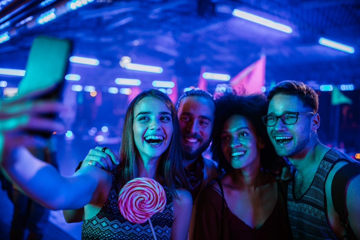 Two couples posing for picture in a nightclub