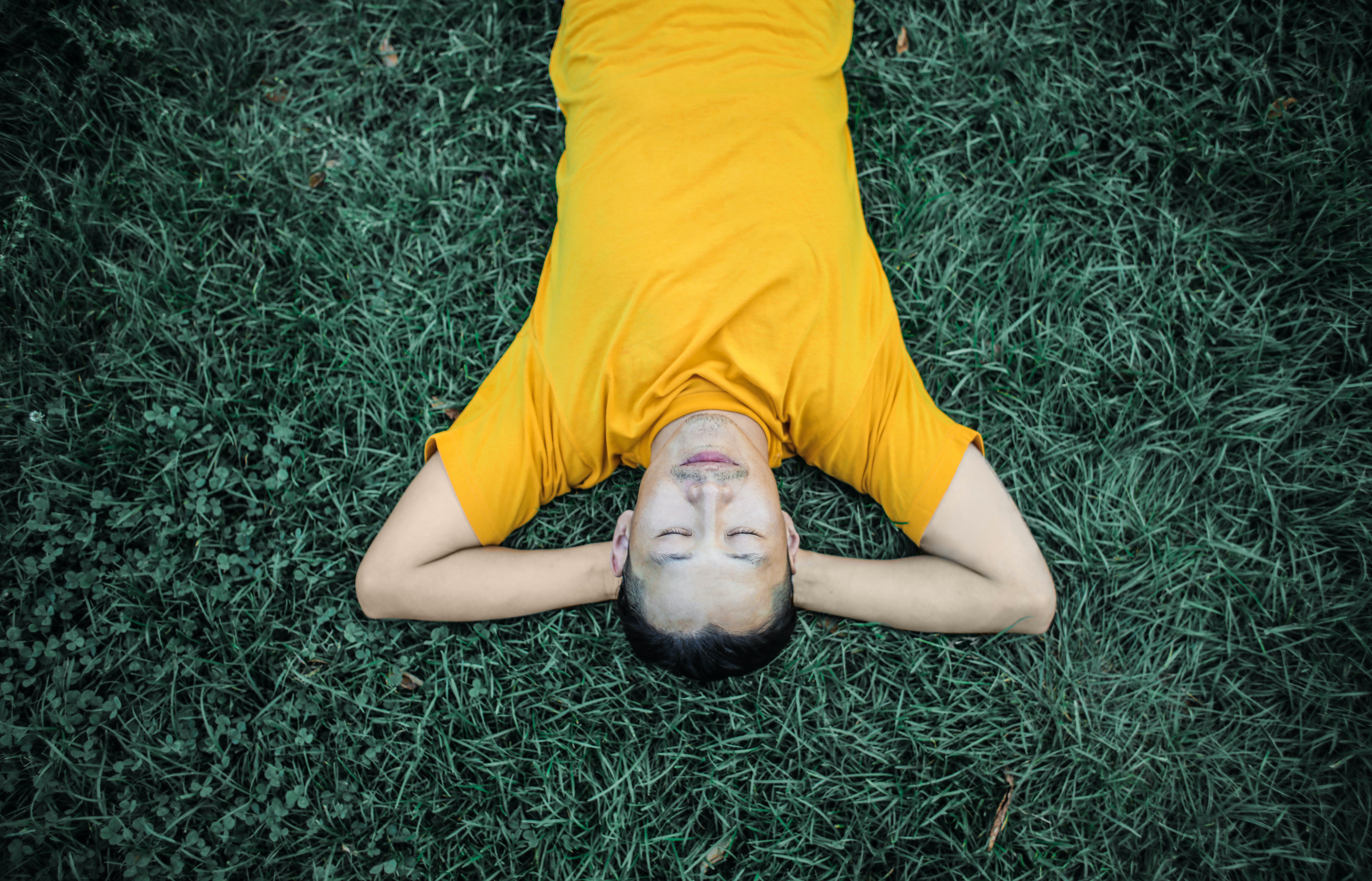 man laying in a field enjoying the stillness