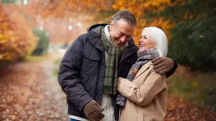 Older couple smiling and walking together in autumn