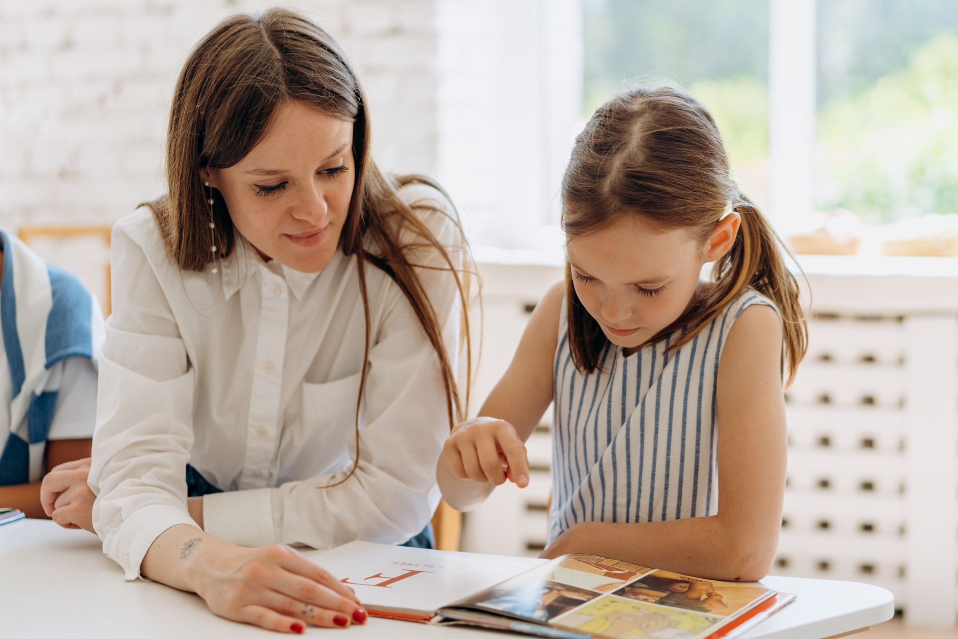mother helping daughter with school assignment