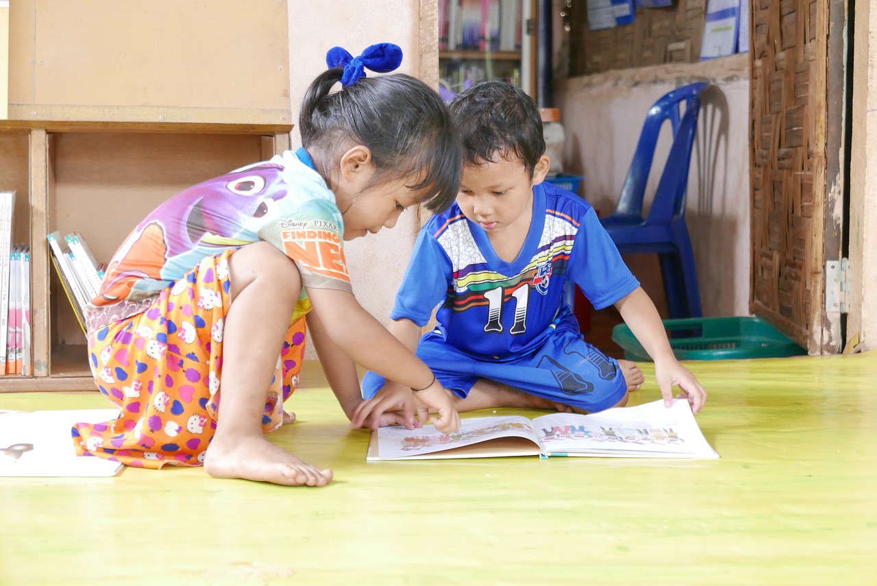 two children reading books at the library