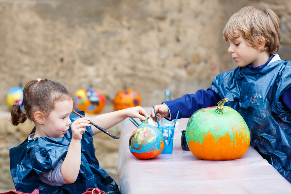 two children painting pumpkins