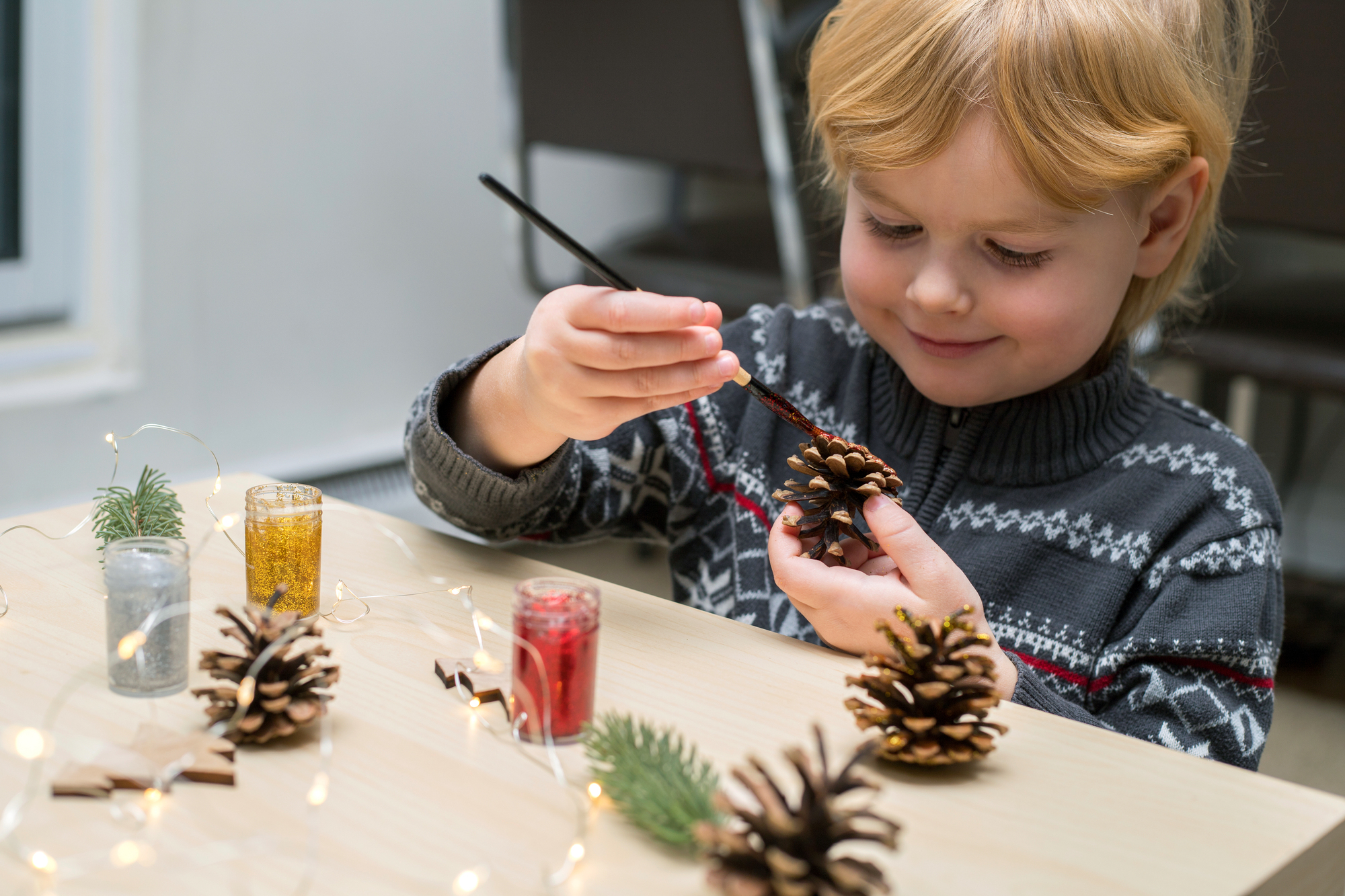 boy painting pinecones