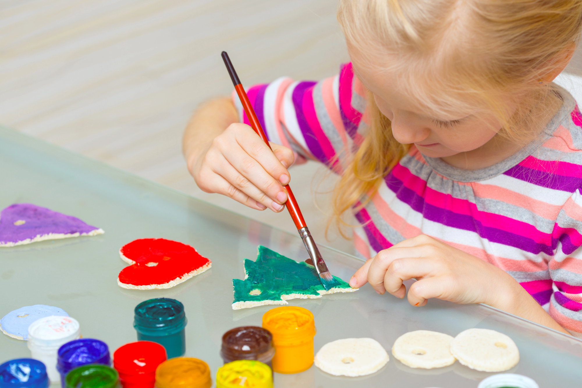 girl painting a salt dough ornament 