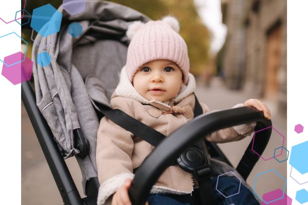 A toddler aged baby sitting in a buggy, wrapped up in a hat and coat. She is looking at the camera and looking happy as she is out on a nature walk around Welwyn Garden City. A toddler aged baby sitting in a buggy, wrapped up in a hat and coat. She is looking at the camera and looking happy as she is out on a nature walk around Welwyn Garden City.