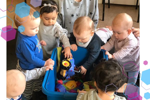 A group of babies at a CubCare baby class getting toys out of a box A group of babies at a CubCare baby class getting toys out of a box