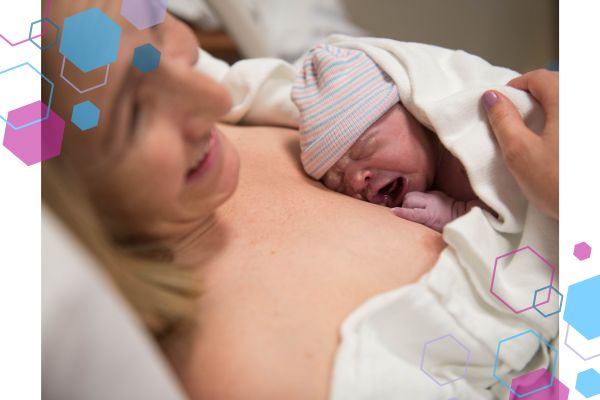 Image of a mum and baby. Mum is lying in a bed just after giving birth and is smiling and looking relaxed. Baby is on her chest, wearing a tiny hat and crying. Image of a mum and baby. Mum is lying in a bed just after giving birth and is smiling and looking relaxed. Baby is on her chest, wearing a tiny hat and crying.