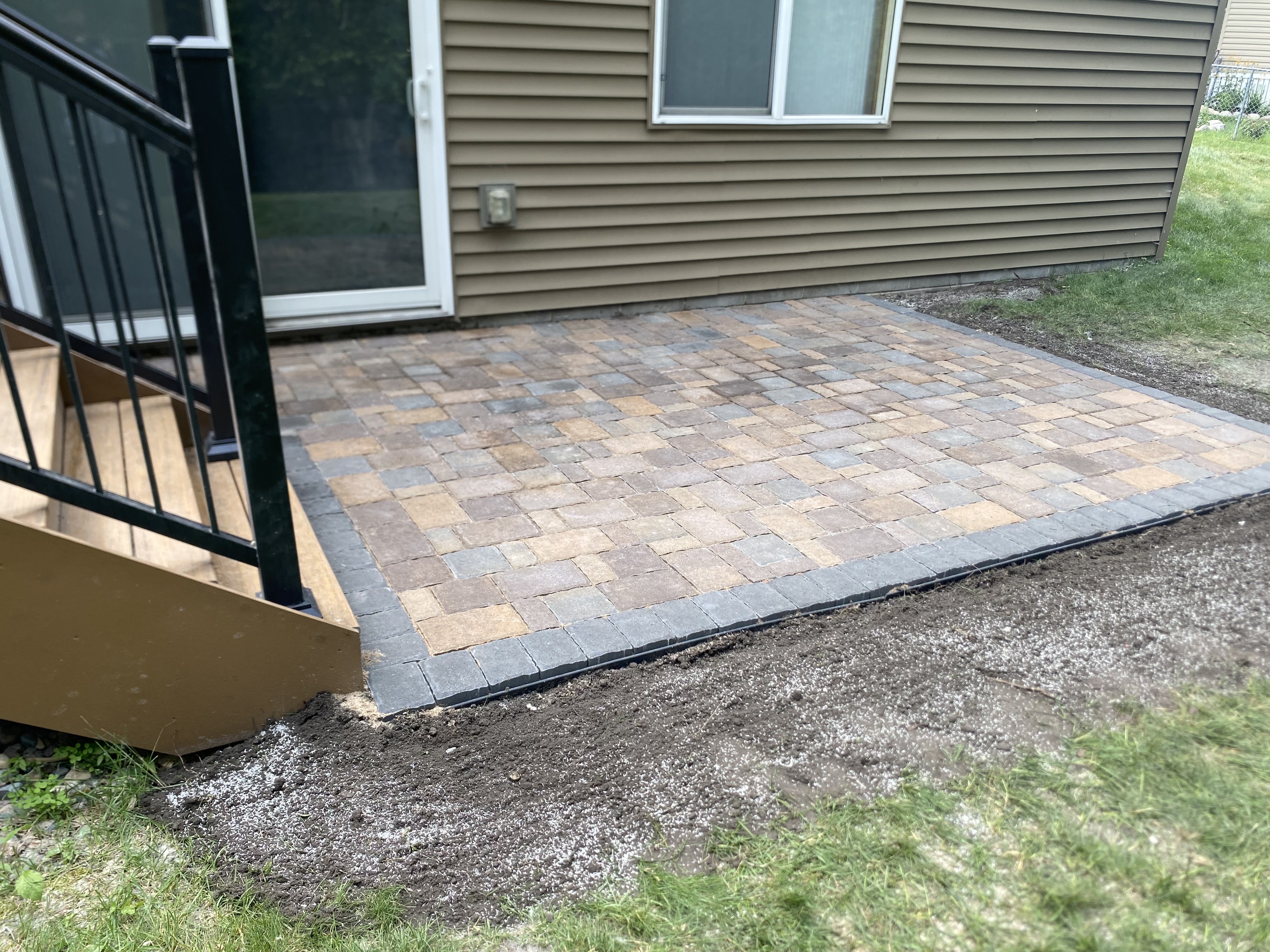 Custom-designed paver patio with a rectangular layout, set in a backyard Custom-designed paver patio with a rectangular layout, set in a backyard
