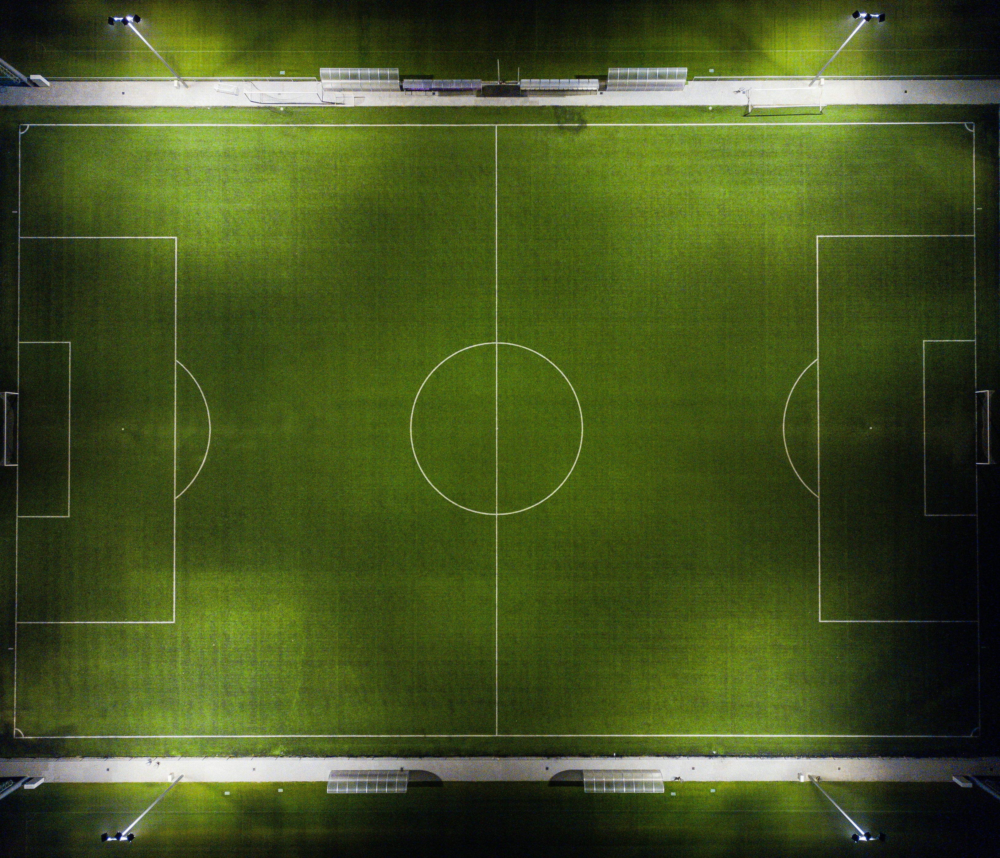 Overhead view of a green football pitch with its lines painted in white Overhead view of a green football pitch with its lines painted in white