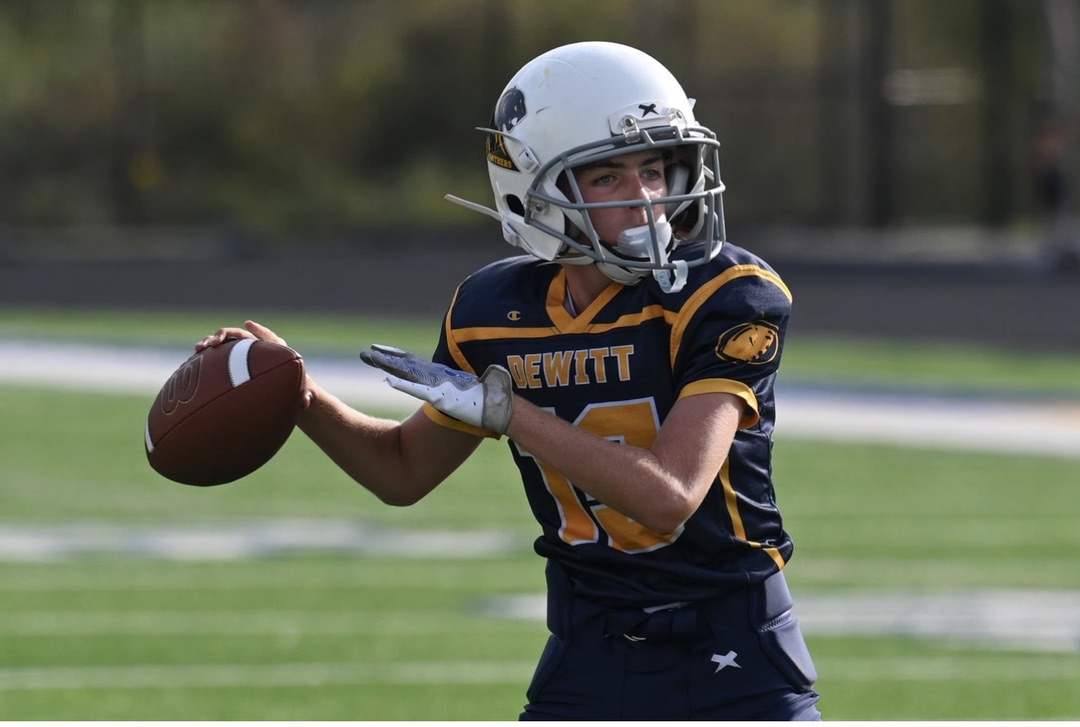 Youth football quarterback preparing to pass the ball, representing focus, leadership, and the discipline entrepreneurs need to execute their game plan.