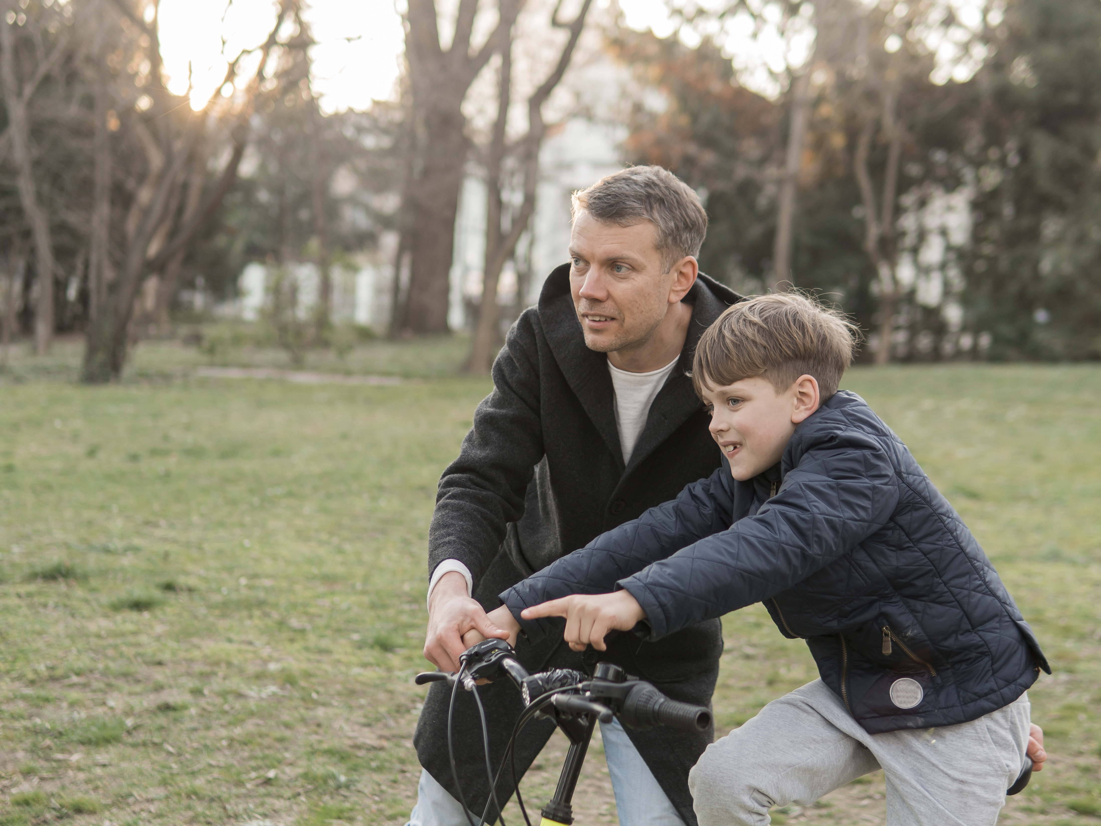 Father teaching his son how to ride a bike in the park