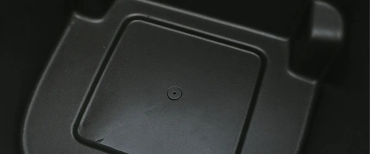 Close-up view of a clean black trash bin bottom interior