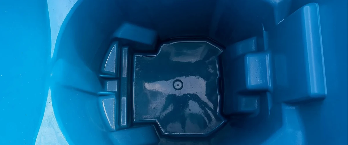 Sparkling clean interior of a blue trash bin after professional washing.