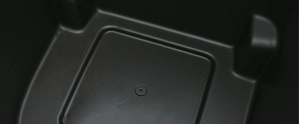 Close-up of a clean black trash bin interior after washing.
