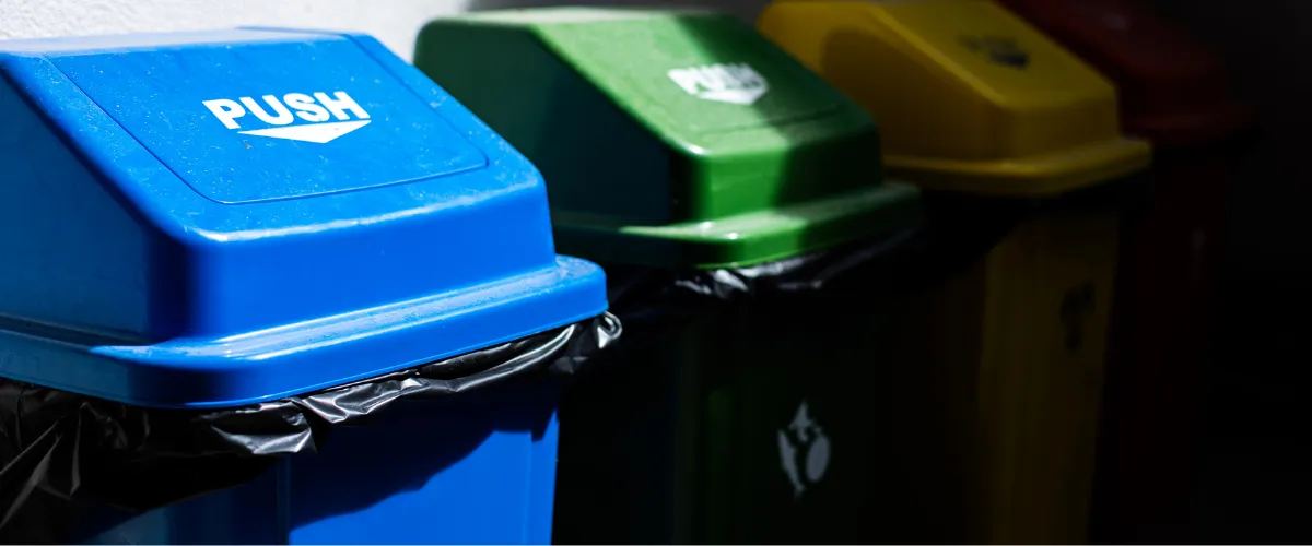 Row of color-coded recycling bins for waste separation in sunlight Row of color-coded recycling bins for waste separation in sunlight