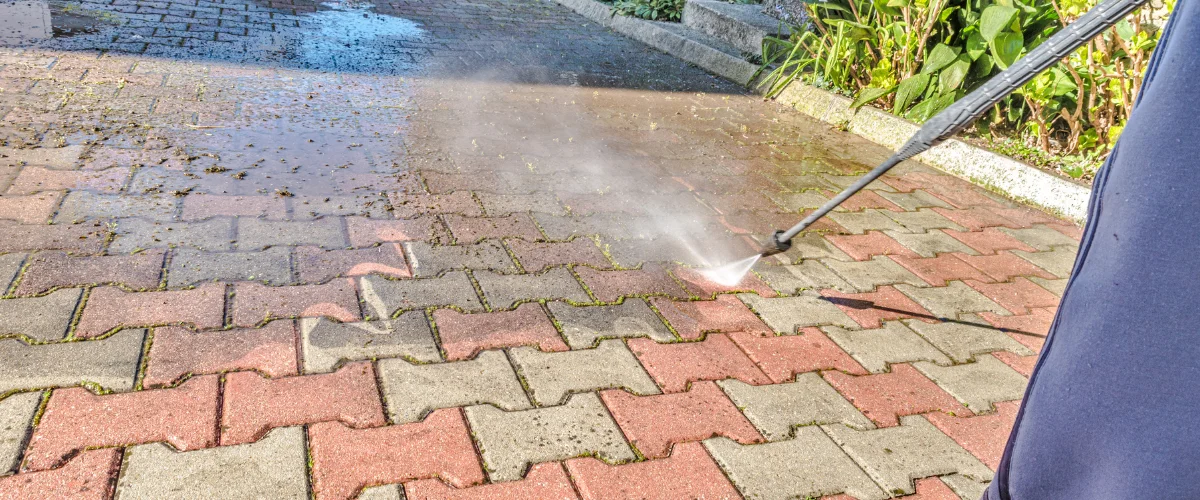 Professional driveway pressure washing removing dirt and grime from brick pavement Professional driveway pressure washing removing dirt and grime from brick pavement