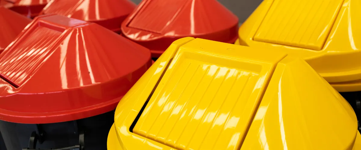 Red and yellow recycling bin lids arranged in a group. Red and yellow recycling bin lids arranged in a group.