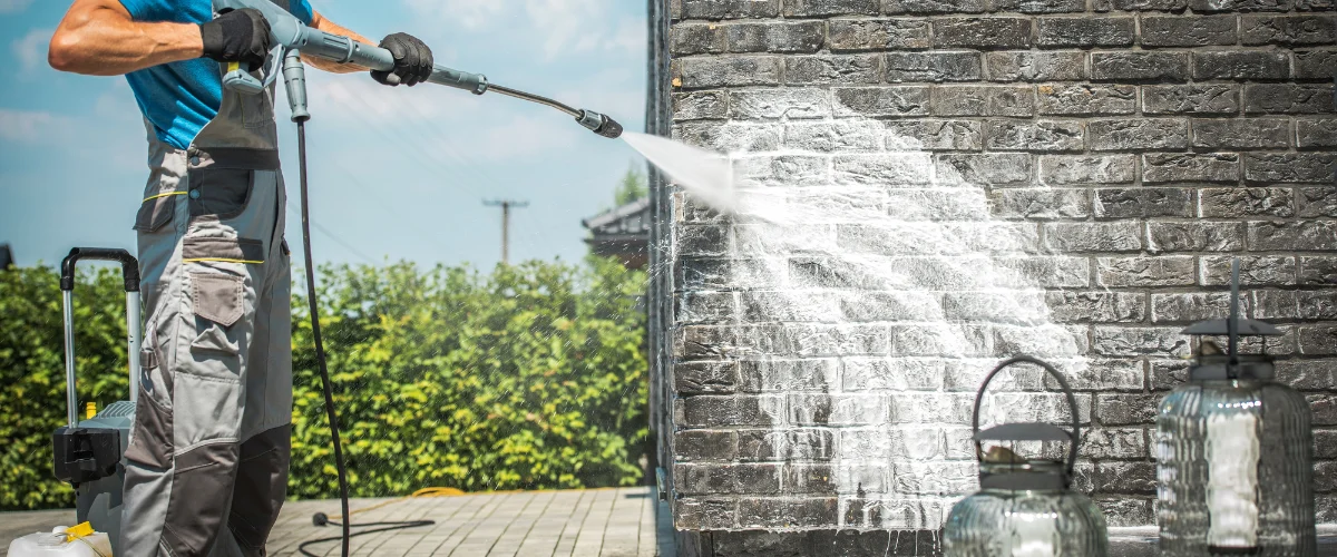 Exterior brick wall being pressure washed to remove stains and buildup