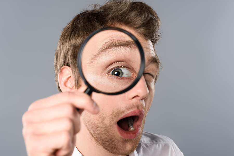 businessman looking through a magnifying glass businessman looking through a magnifying glass