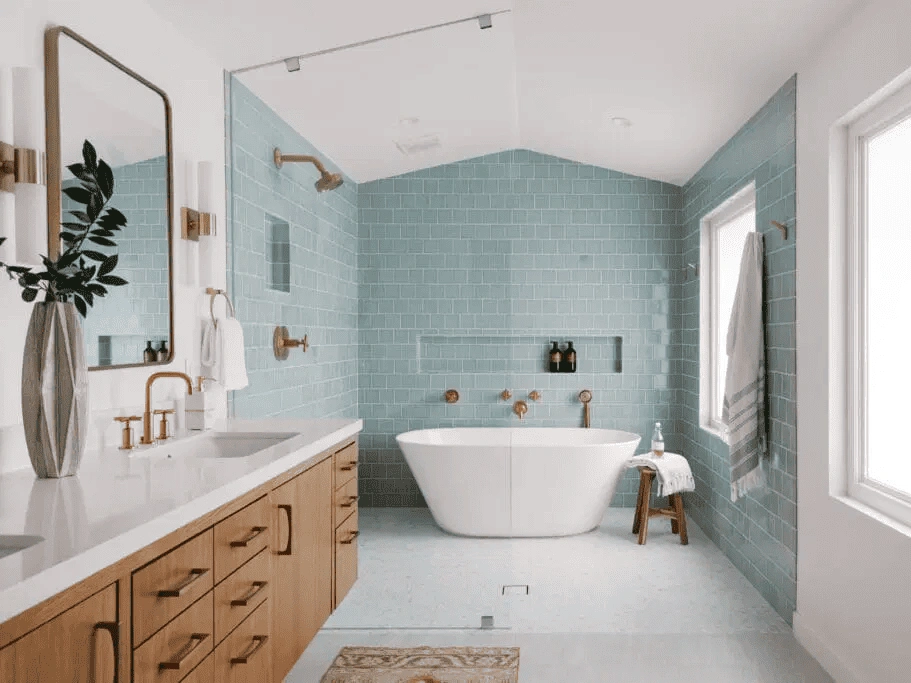 a bathroom remodeling project featuring a serene design with a freestanding bathtub, wooden vanity, large mirror, and soft blue walls.