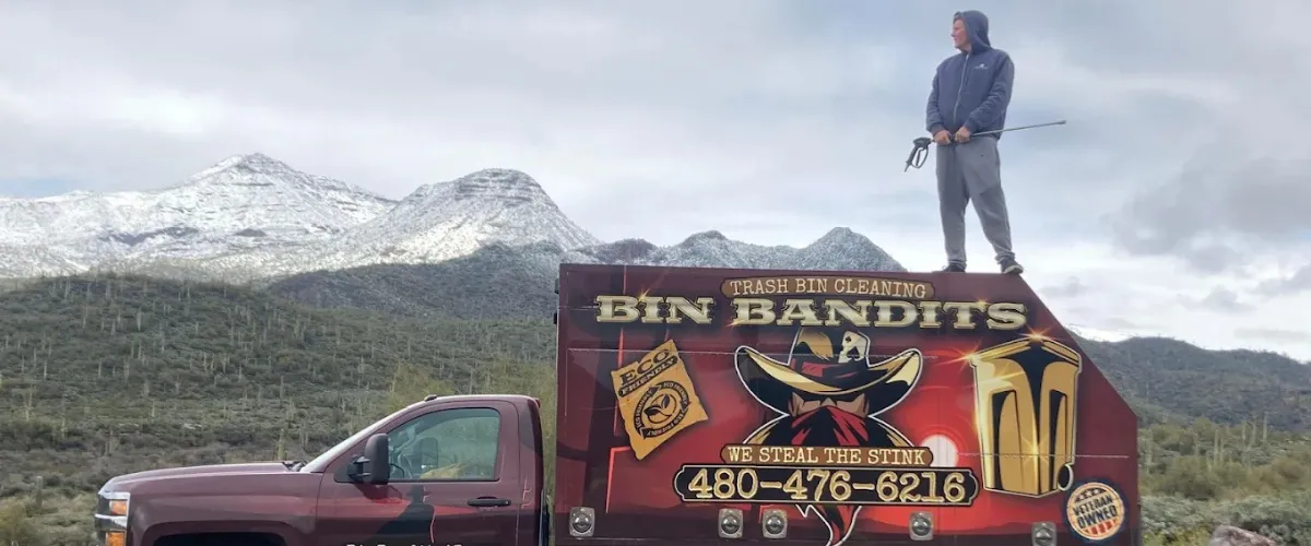 Bin Bandits trash bin cleaning truck parked in front of a scenic Arizona desert with mountains and cloudy skies. Bin Bandits trash bin cleaning truck parked in front of a scenic Arizona desert with mountains and cloudy skies.