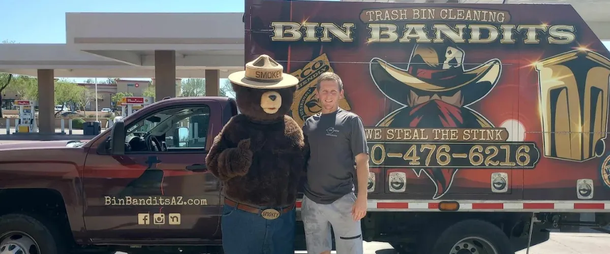Bin Bandits truck at a gas station with a crew member posing next to Smokey Bear. Bin Bandits truck at a gas station with a crew member posing next to Smokey Bear.