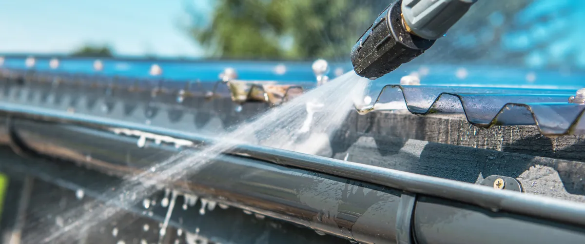 Close-up of gutter cleaning using a pressure washing nozzle Close-up of gutter cleaning using a pressure washing nozzle