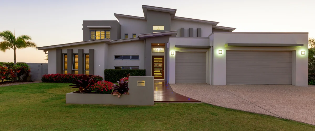 Modern home exterior with clean landscaping and evening lights
