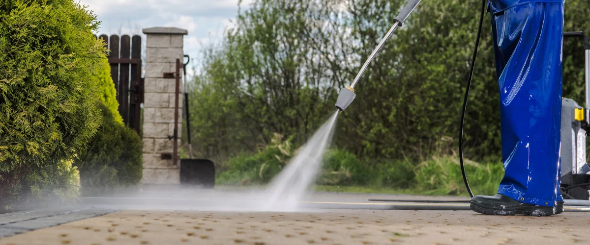 Pressure washing concrete driveway surface to remove grime Pressure washing concrete driveway surface to remove grime