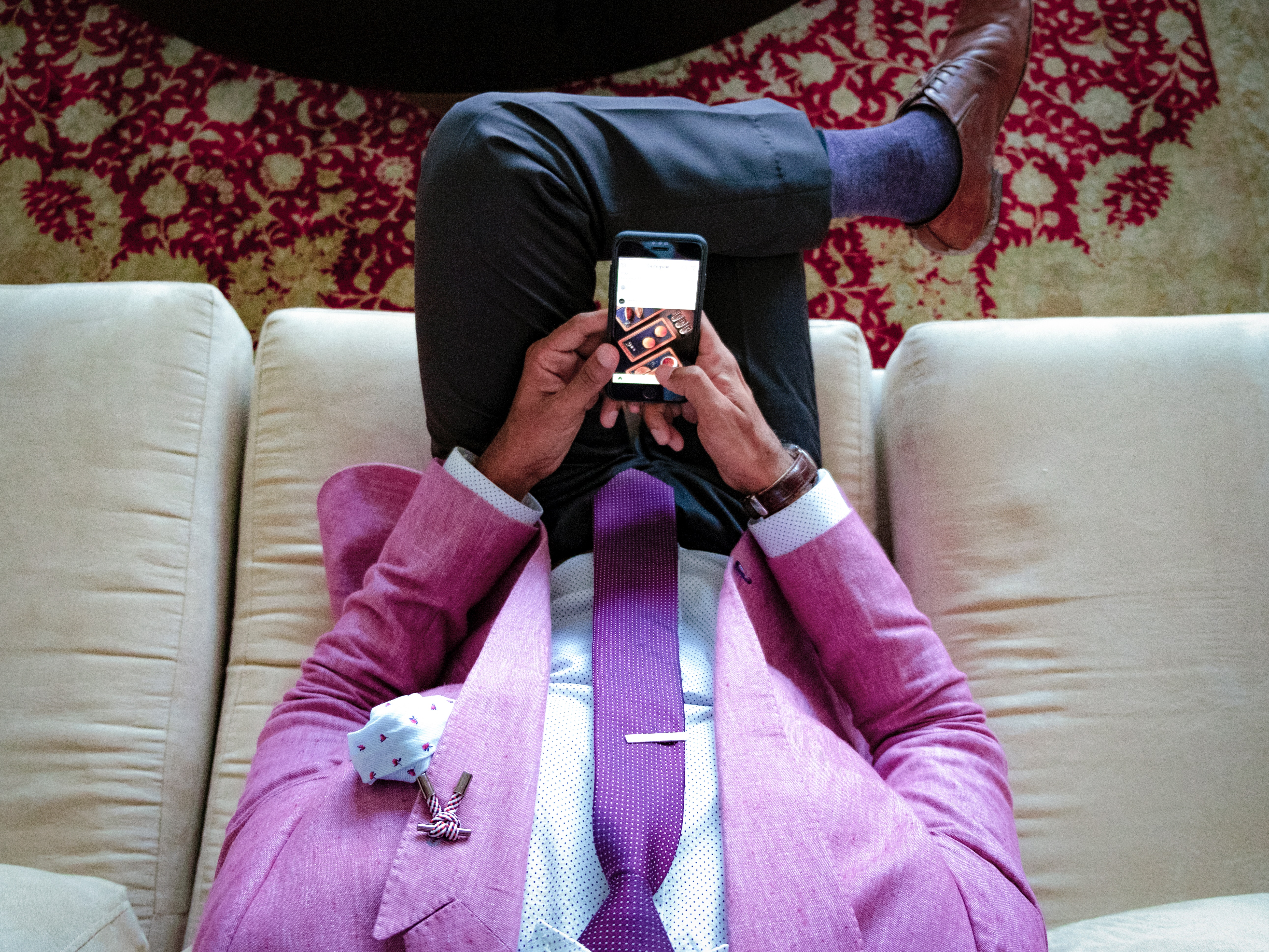 A man in a pink linen blazer with a purple tie, white dress shirt and charcoal dress pants A man in a pink linen blazer with a purple tie, white dress shirt and charcoal dress pants