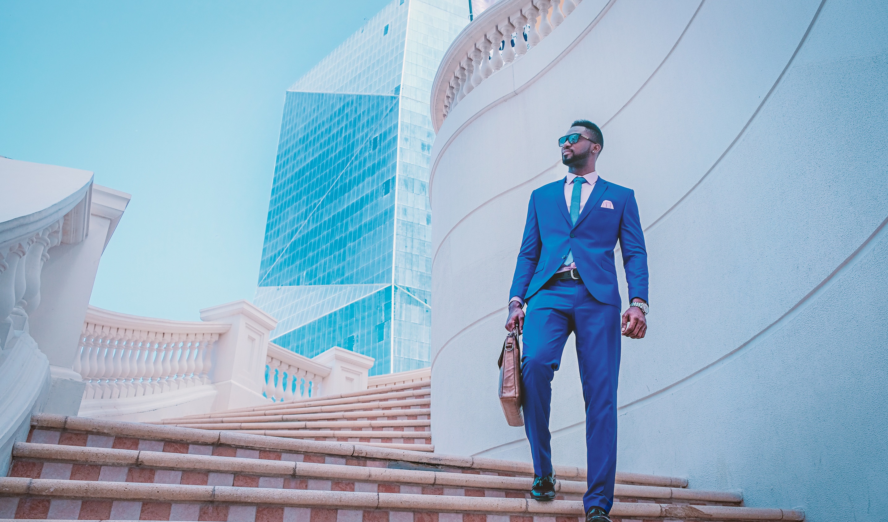 A man wearing a true blue cobalt suit walking down stairs A man wearing a true blue cobalt suit walking down stairs