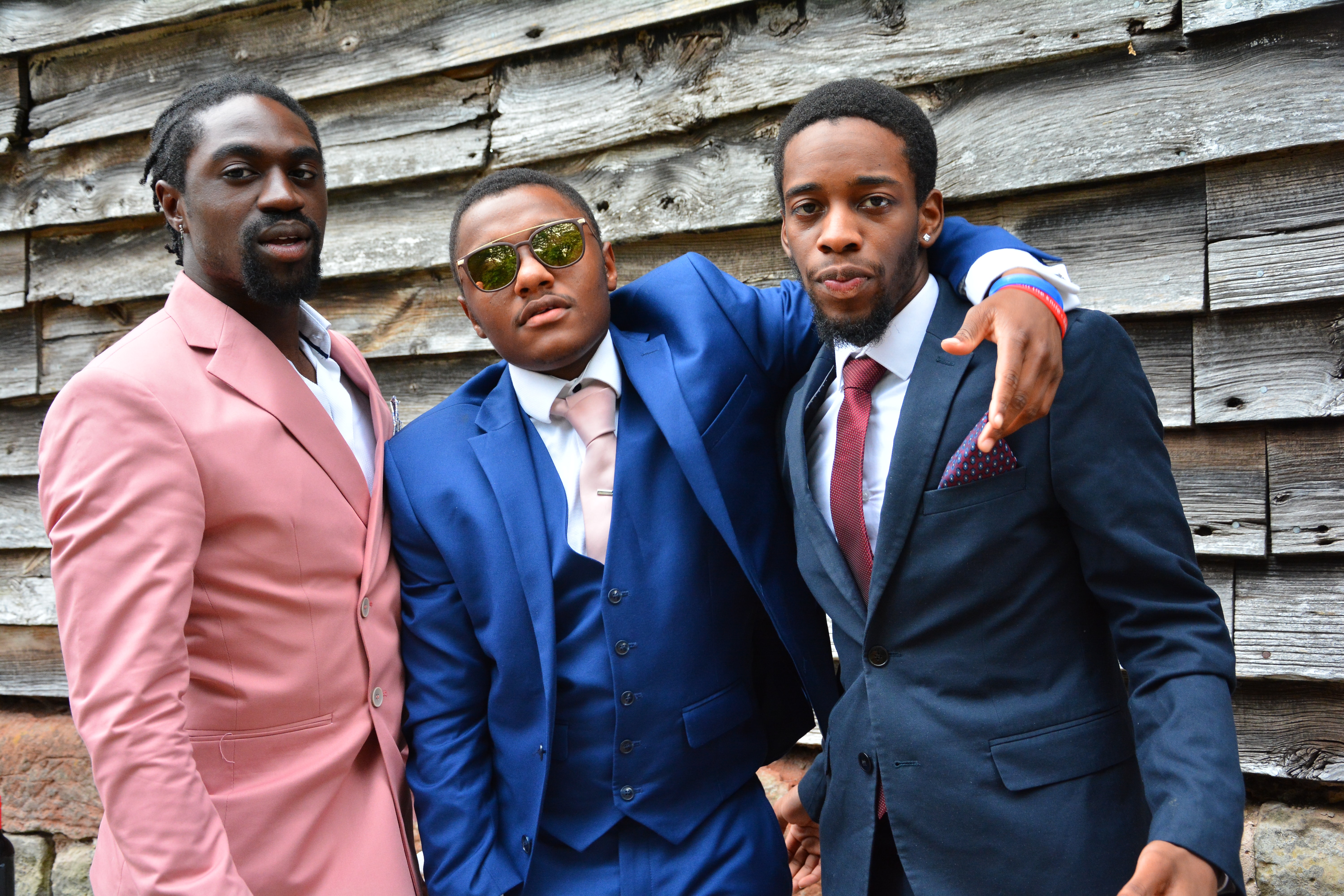 Three guys in suits. Two are bold in color but have neutral accents to keep the bold color the focal point Three guys in suits. Two are bold in color but have neutral accents to keep the bold color the focal point