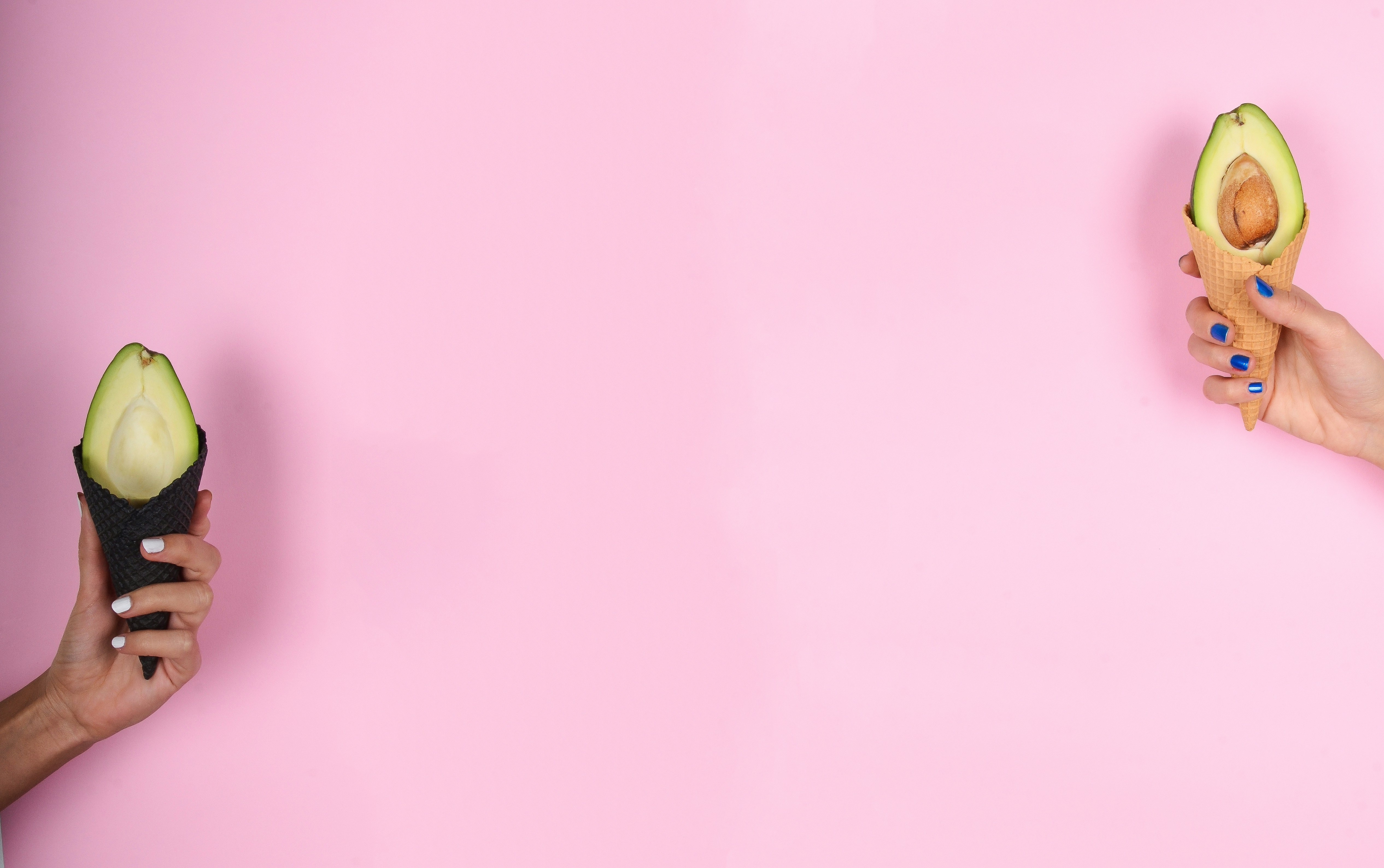 Pink background with ice cones with avocados on each side of the image Pink background with ice cones with avocados on each side of the image