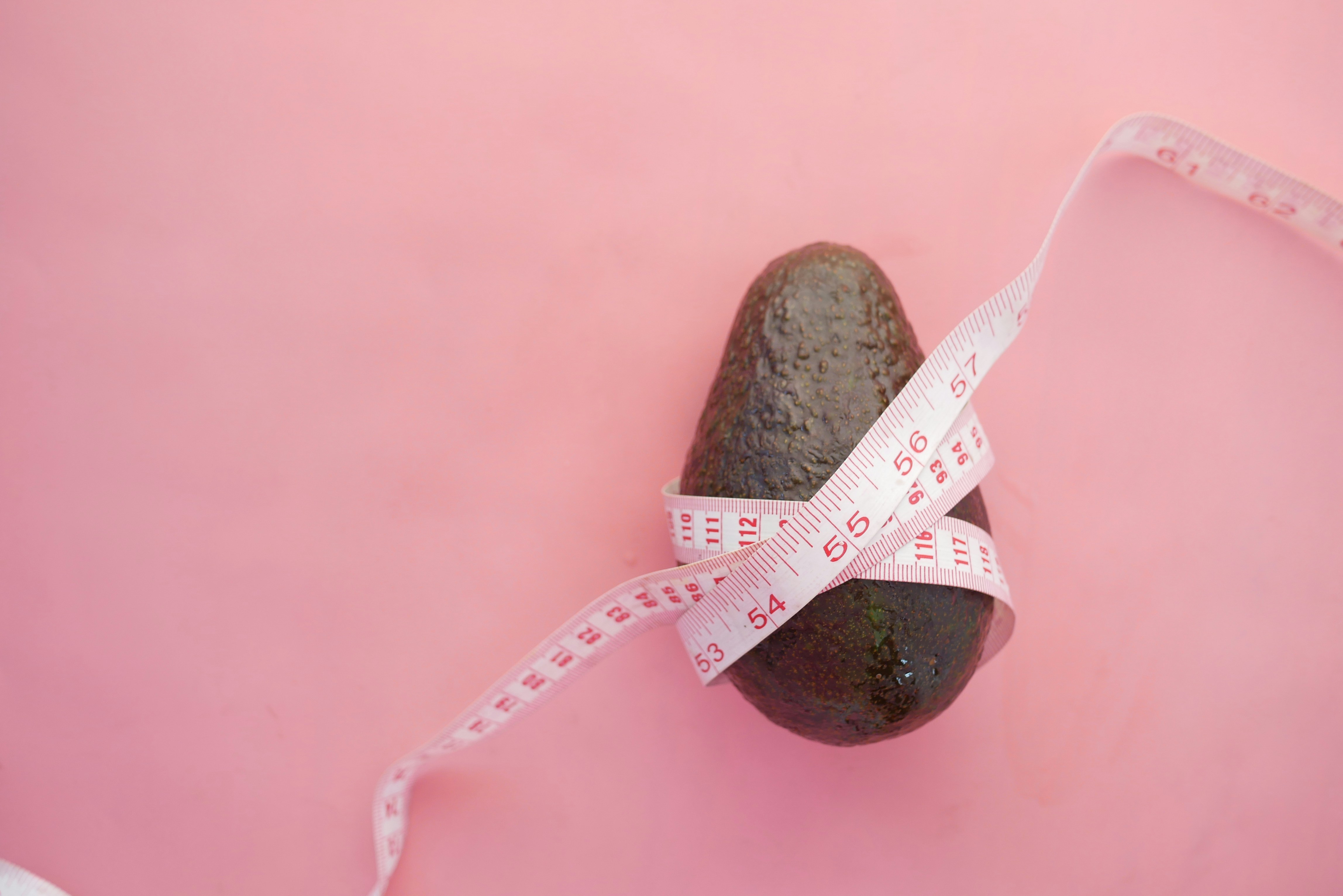 Avocado with measuring tape wrapped around it Avocado with measuring tape wrapped around it
