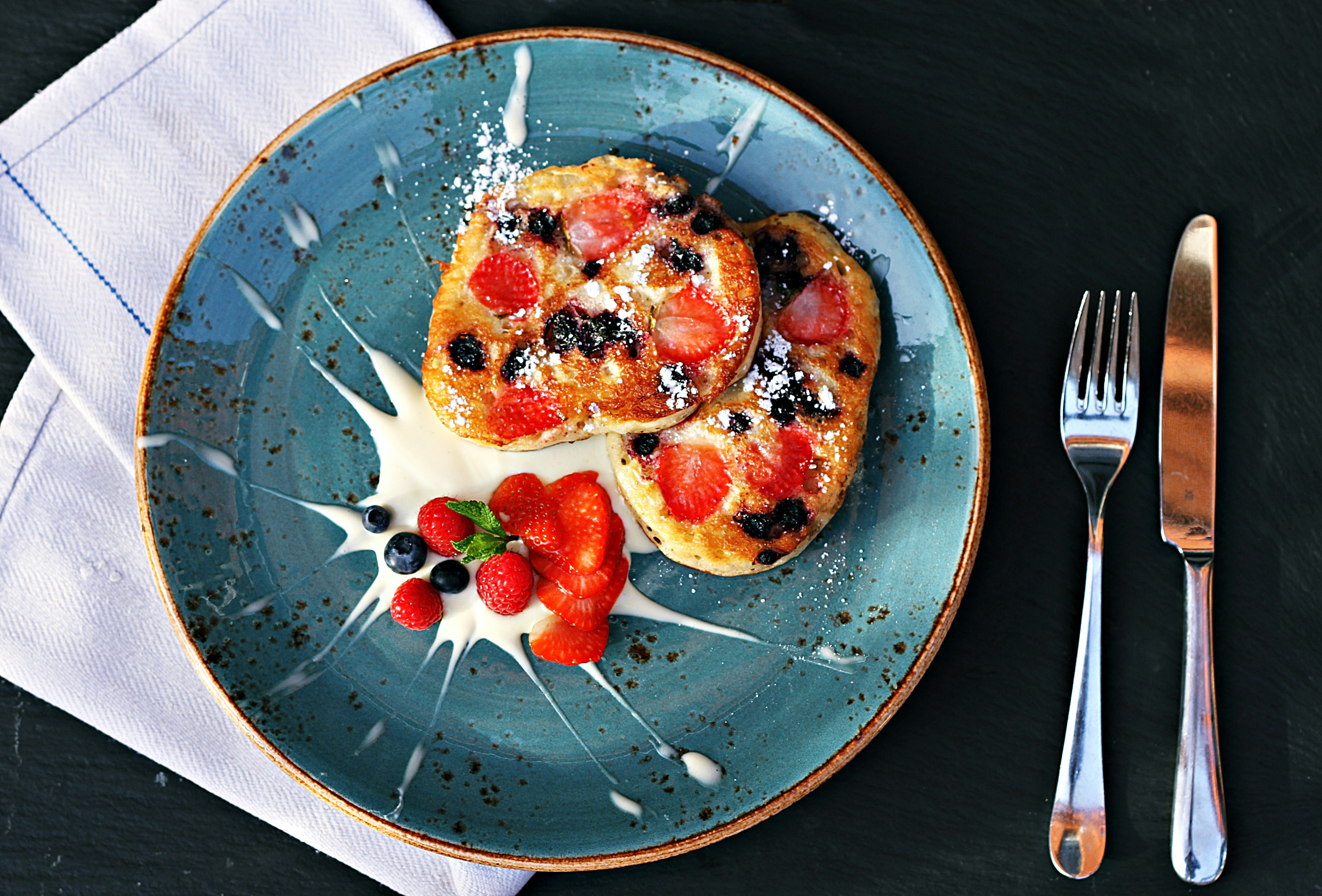 pancakes with berries on a blue plate pancakes with berries on a blue plate