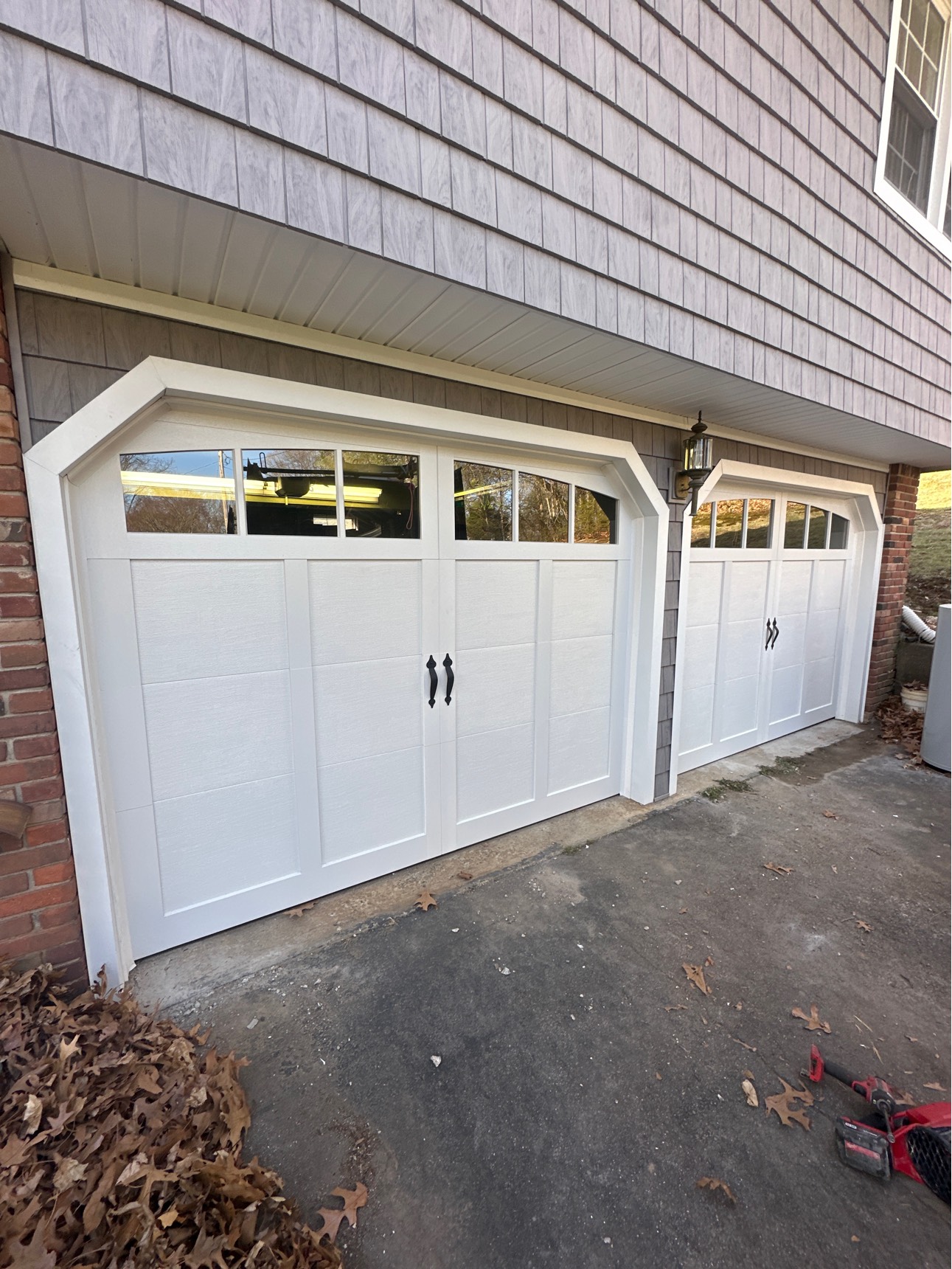White carriage-style garage doors on gray home