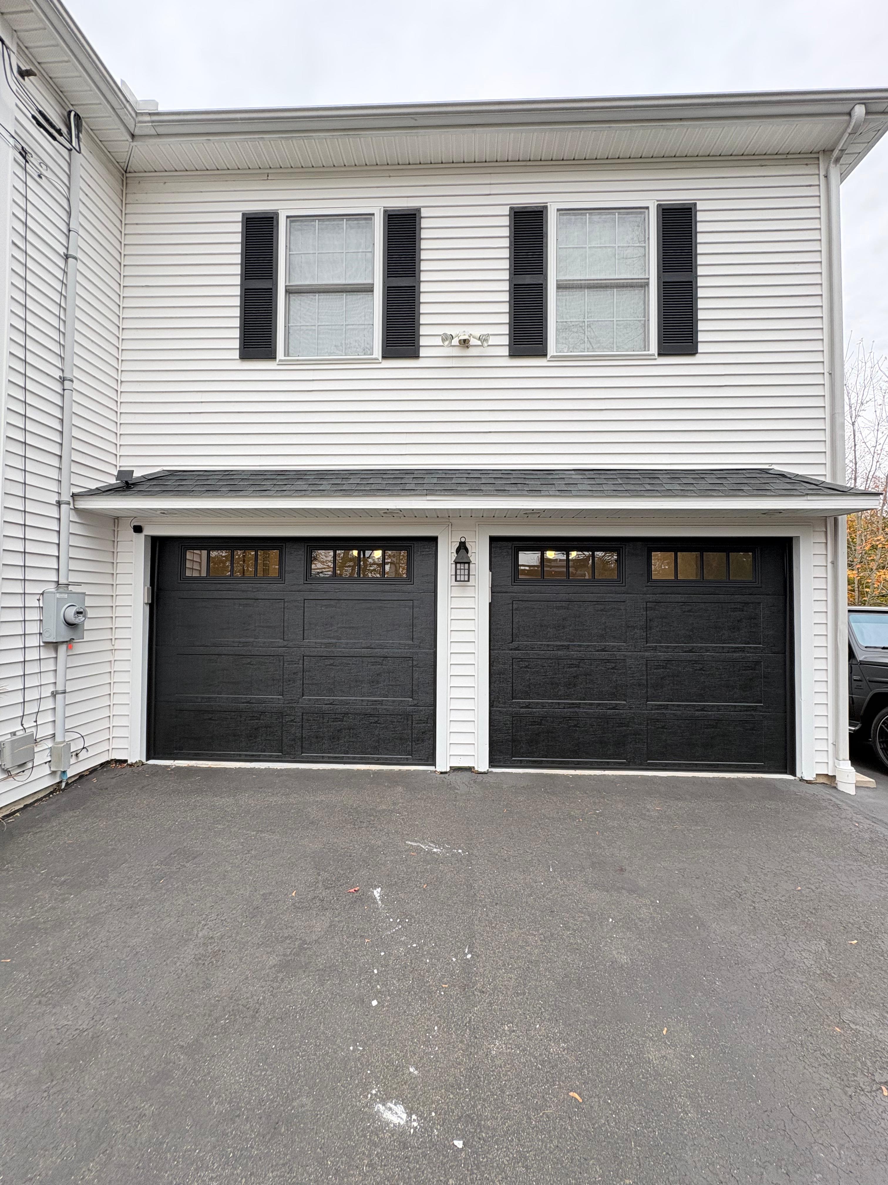 Black garage doors on white siding home