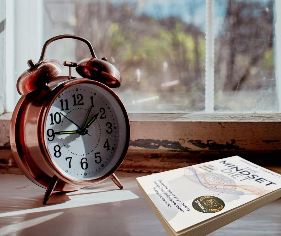 The Mindset Diet book by the clock and a window