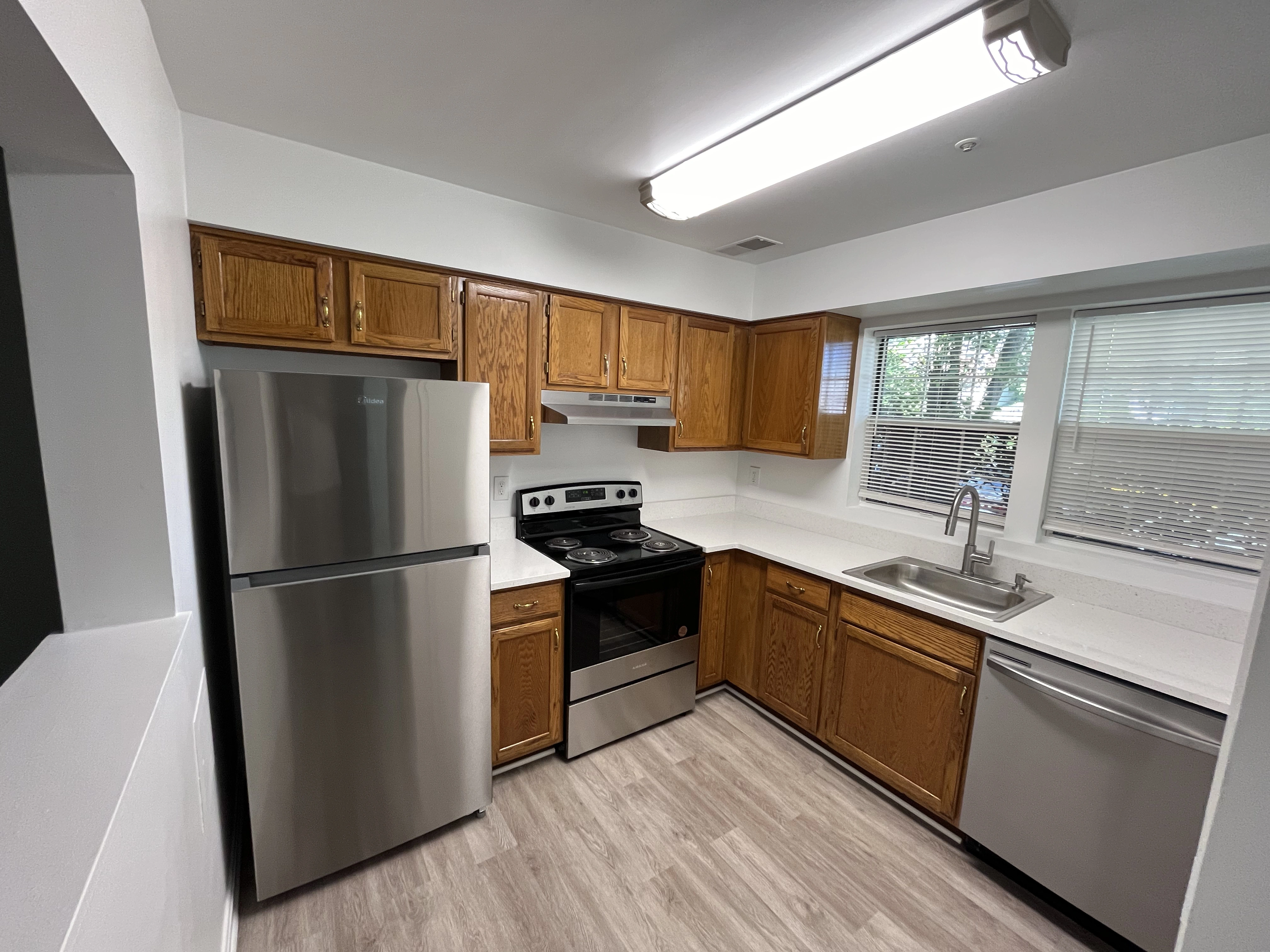 A modern kitchen featuring stainless steel appliances and warm wood cabinets, creating a stylish and functional space.