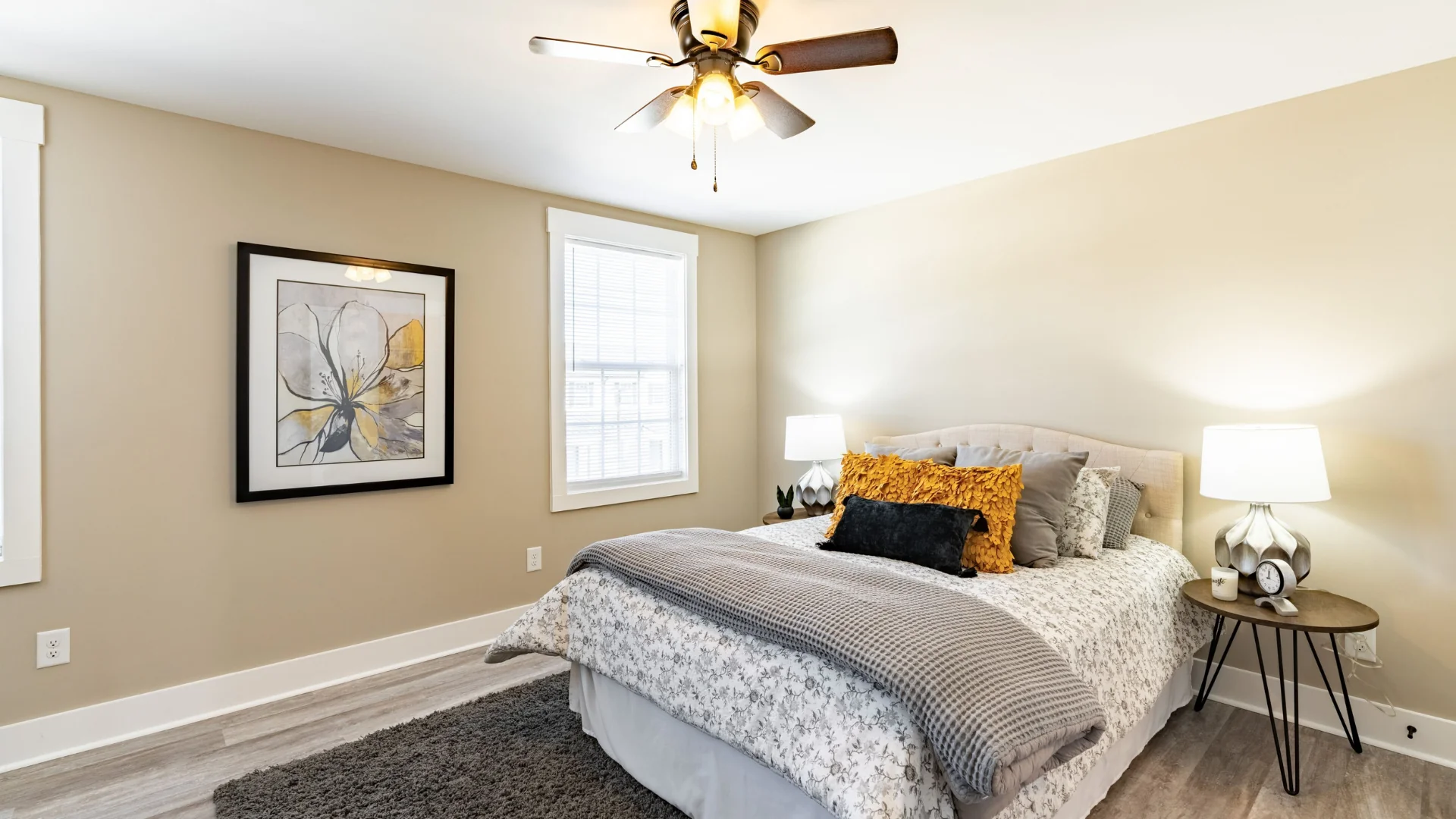 Modern bedroom with bed, lamps, and large window.