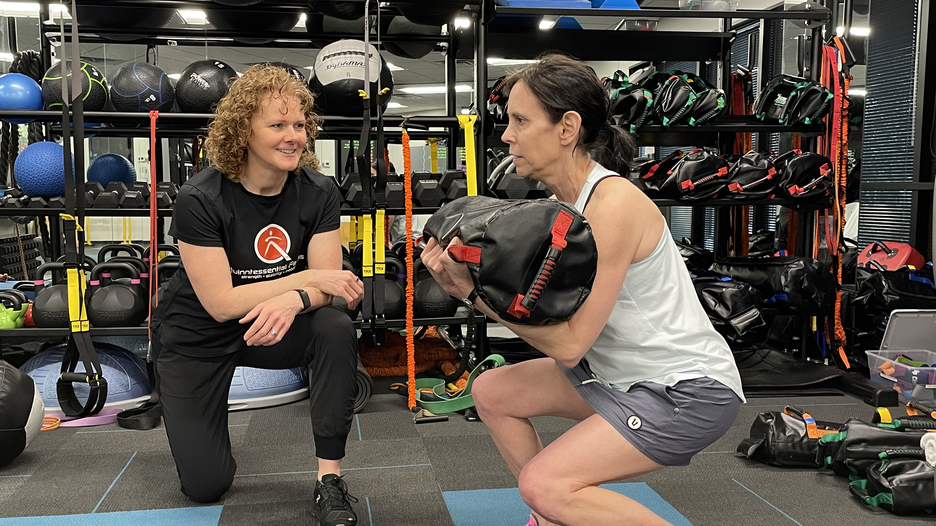 coach and the women working on strength training in a personal training coach and the women working on strength training in a personal training