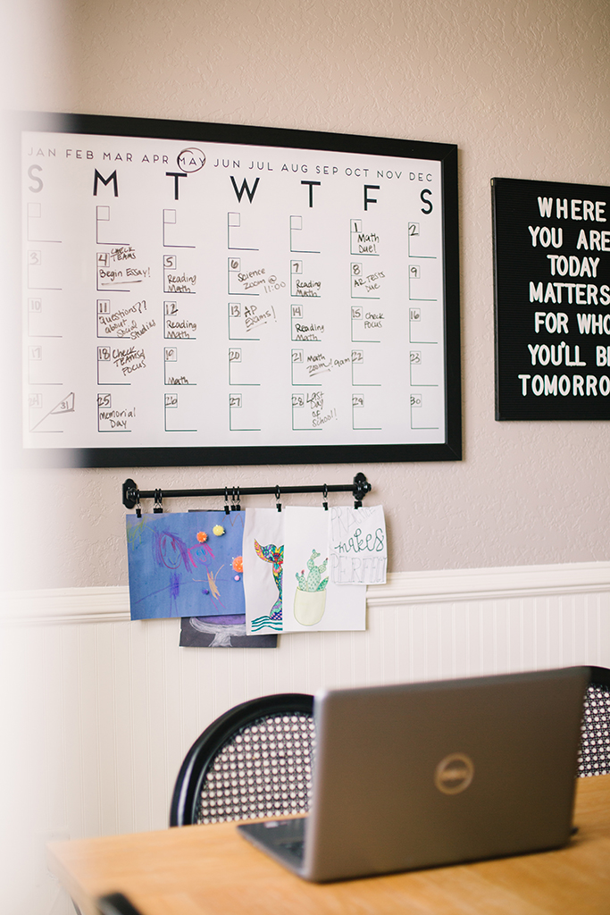 desk with laptop and wall planner in the background desk with laptop and wall planner in the background