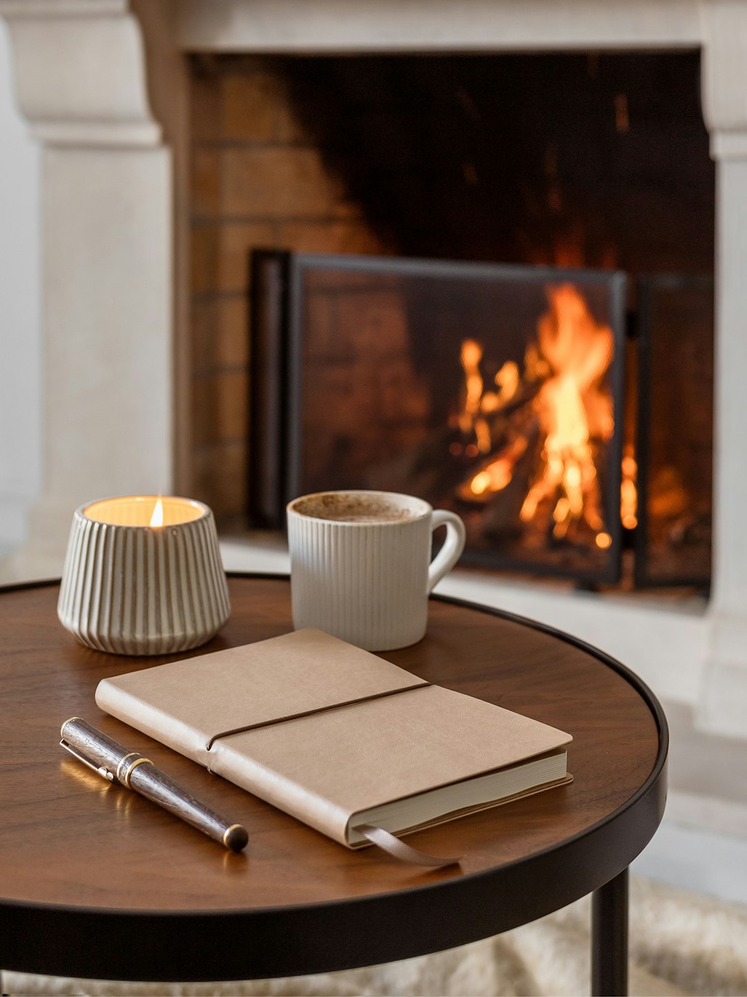 coffee table with journal and coffee and a fire in the background coffee table with journal and coffee and a fire in the background